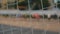 A close-up of the grid of football gates. Blurred background runners at football team training