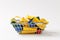 Close up of grocery basket for shopping in supermarket with yellow handles filled with multi-colored geometric shapes
