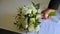 Close up of groom takes wedding bouquet and goes