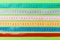 Close up of a group of colorful measure tapes lying in rows as a background. Diet concept on green background