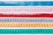 Close up of a group of colorful measure tapes lying in rows as a background. Diet concept on wooden background