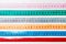 Close up of a group of colorful measure tapes lying in rows as a background. Diet concept on wooden background