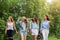 Close up of group of four girlfriends going home after walking together at park. female students walking after study