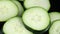 Close-up of group of fresh cucumber slices floating in liquid