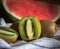 Close-up of a group of kiwis.. A red watermelon on the background