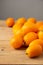 Close-up of a group of kumquats on a rustic wooden table, gray background, with selective focus,