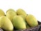 close-up group of mangoes in wicker basket isolated on white background