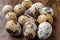 Close-up of group of quail eggs, with selective focus, on dark wooden table