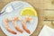 Close up of a group of shrimps and a lemon served on a white plate, viewed from above
