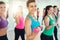 Close-up of group of young women doing exercise with dumbbells