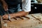 Close-up of guitar luthier using chisel to shave bracing of acoustic guitar