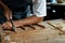 Close-up of guitar luthier using chisel to shave bracing of acoustic guitar