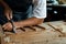 Close-up of guitar luthier using chisel to shave bracing of acoustic guitar