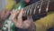 A close-up of a guitar master`s hand sliding on the neck playing chords, scales and solos on a metallic green vintage electric