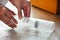 Close up of a guy`s hands using bubble wrap to pack a glass bottle before put into cardboard box deliver to customer