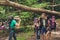 Close up of a guy shooting a portrait of his three friends in the summer nice wood. They are hikers, walking and picking place for