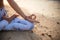 Close up gyan mudra. Focus on hand. Yoga on the beach. Lotus yoga pose. Yogi woman sitting on sand, meditating, practicing yoga