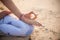 Close up gyan mudra. Focus on hand. Yoga on the beach. Lotus yoga pose. Yogi woman sitting on sand, meditating, practicing yoga