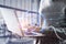 Close up of hacker hands using laptop with glowing circuit padlock sign on blurry office interior background. Safety, secure and