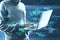 Close up of hacker using laptop with creative coding html language on blurry office interior background. Web developer, hacking,