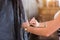 Close up of hairdresser holding scissors and comb and makes a haircut woman client