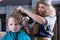 Close-up of hairdresser spraying boy hair