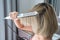 Close-up of a hairdresser straightening gold hair with hair iron