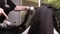 Close up of hairdressers hands drying long blond hair with blow dryer and round brush.