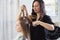 Close up of hairdressers hands drying long blond hair with blow dryer and round brush