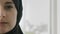 Close up half female face of Muslim woman in black hijab indoors. Portrait Islamic Arabian girl with natural make up