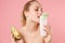 Close up half naked woman 20s perfect skin nude make up blue eyes hold in hand fresh avocado bottle isolated on pastel