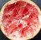 Close up of half squeezed grapefruit on the dark surface