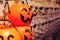 Close up of Halloween decorations; smiling pumpkin trick or treat container in foreground, skull heads in background