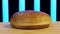 Close up of hamburger bun cut in two. Stock footage. Wheat burger bun lying on wooden surface with flying flour on black