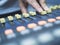 Close up of hand adjustment digital mixing console for recording studio