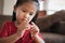 Close up hand of asian child girl is threading beads onto a string