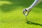 Close up hand asian sporty woman putting golf ball on tee with club in golf course on evening on time for healthy sport. Banner an