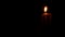 Close up hand burning match lights candle in complete darkness. Light fire wax candle burning in black darkness. Prayer