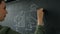 Close up of a hand of a businesswoman wearing a black suit drawing a business idea sketch on a blackboard. 20s 4k.