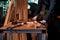 Close-up the hand of carpenter craftsman making pool cue or snooker cue with a manual hand wood planer in carpentry workplace.