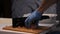 Close-up of hand chef cutting meat.