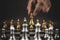 Close up hand choose gold chess to challenge with silve chess team on chess board