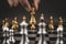Close up hand choose gold chess to challenge with silve chess team on chess board