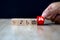 Close-up hand choose a red cube wooden toy blocks stacked with family icon for safety family insurance