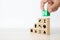 Close-up hand choose wooden toy blocks stacked with door exit sing icon