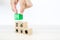 Close-up hand choose wooden toy blocks stacked with door exit sing icon