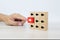 Close-up hand chooses arrow icon on cube wooden toy block stacked with pointing to opposite directions for way of adapting to chan