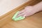 Close up of hand cleaning the wooden oak parquet floor and skirting board