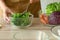 close up. hand cooking food, preparation menu salad, fresh lettuce on a cup with carrot and cauliflower on table kitchen at home