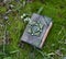 Close up of hand crafted witch diary on the grass in the garden.